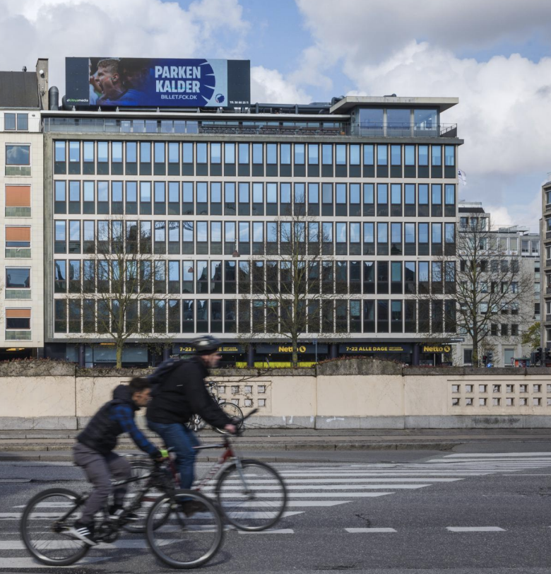 Megaboard ved Vesterport - Digital skærm på taget af bygning med cyklister på gaden